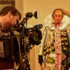 Kameraperson filmt im Franziskanermuseum eine reich bekleidete, gekrönte Marienstatue mit verzierter Robe und weißem Spitzenkragen