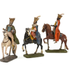 Drei bemalte Metallfiguren reitender Könige (Heilige Drei Könige) mit Kronen und Geschenken, auf zwei Pferden und einem Kamel, in bunten Gewändern, jeweils auf rechteckigen Sockeln.