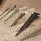 Vier metallene Pfeil- oder Speerspitzen unterschiedlicher Form und Patina auf hellem Ausstellungstuch im Franziskanermuseum